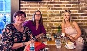 咖啡店里围坐在一张小桌子旁的三个女人