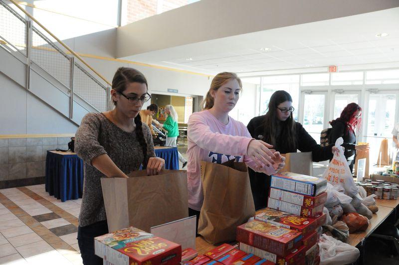 Students stuffing bags with food donations